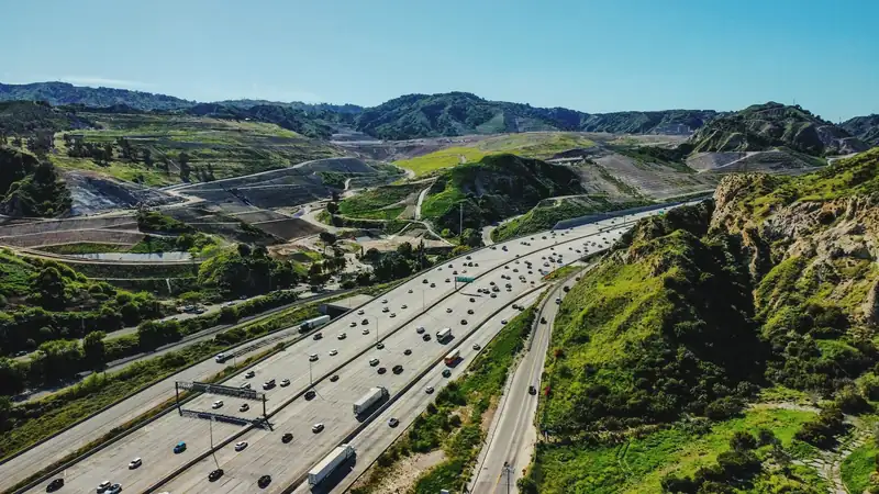 Motorvei med lastebiler sett ovenfra (foto: Marlon Santizo, Unsplash)
